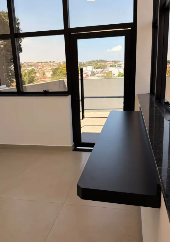 Entrada do escritório pelos fundos, com porta de vidro e vista da cidade