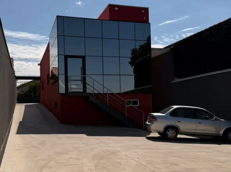 Estacionamento nos fundos do escritório, com a fachada de vidro ao fundo
